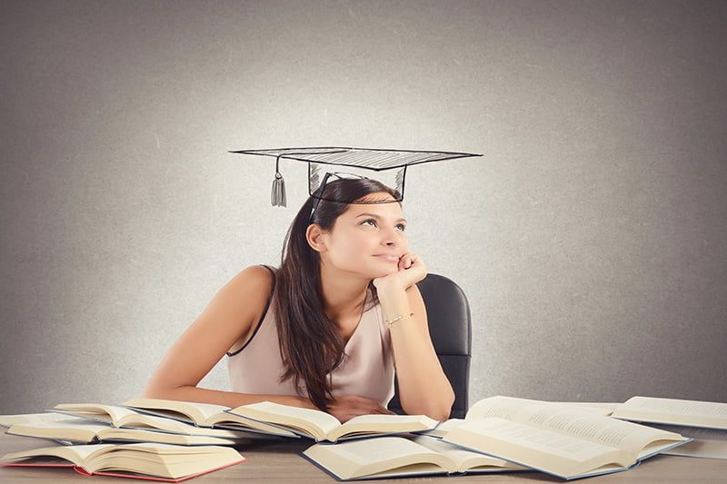Young student between books dreams the graduation