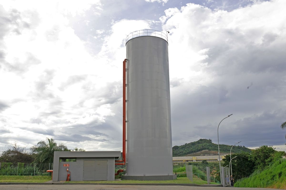 Reservatório metálico vertical para armazenamento de água em área industrial.