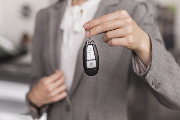close-up-female-hand-holding-car-keys_23-2148384945