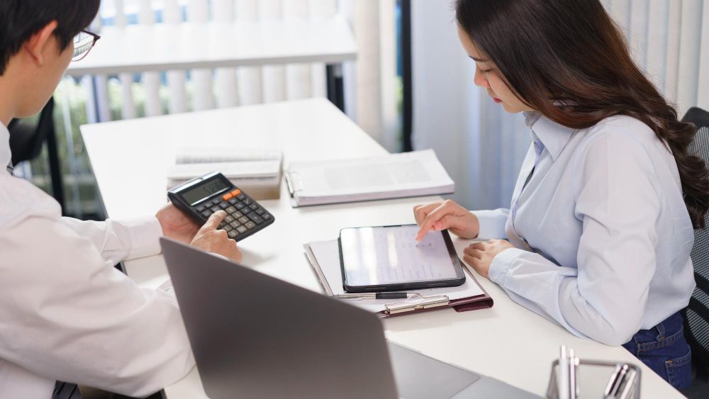 business-concept-business-colleague-show-profit-amount-to-partner-while-checking-financial-data