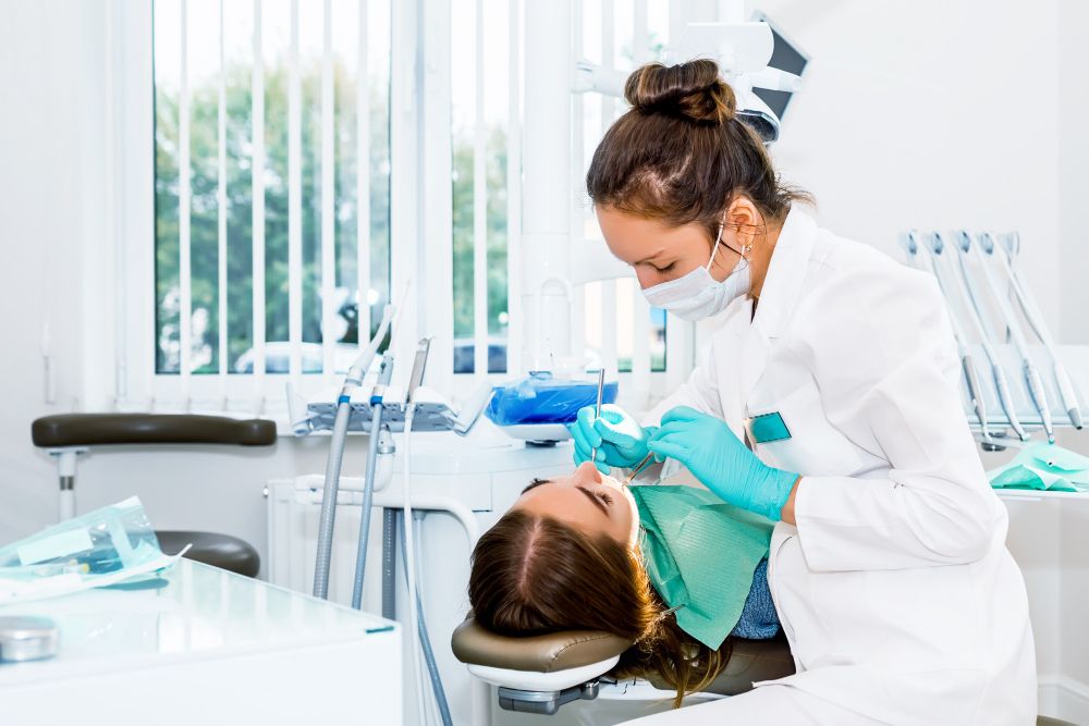 female-dentist-checking-up-patient-teeth-with-braces-at-dental-clinic-office