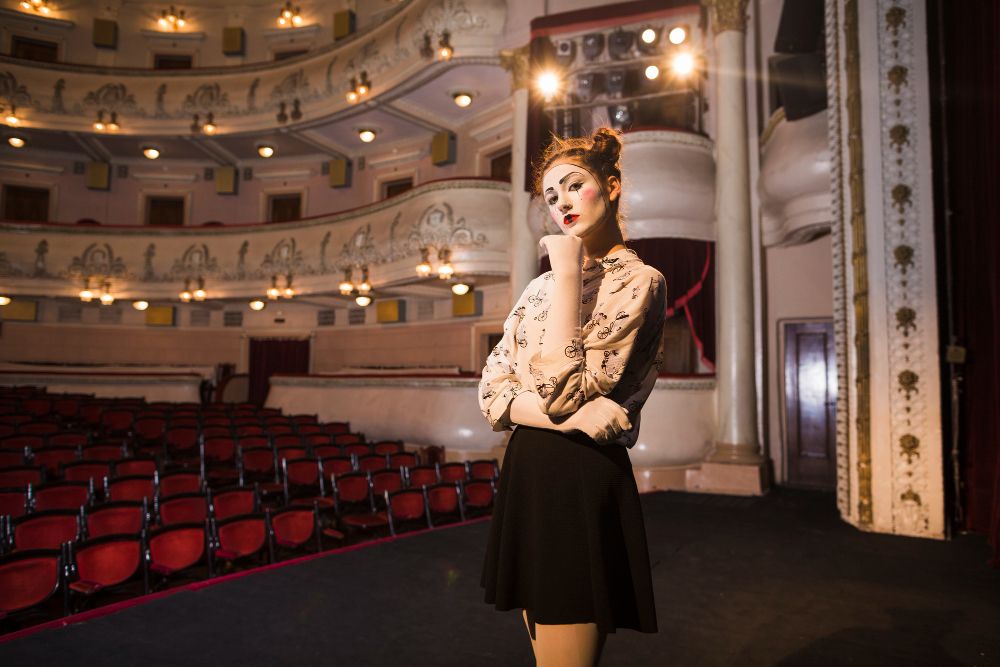 portrait-of-thoughtful-female-mime-artist-standing-on-stage