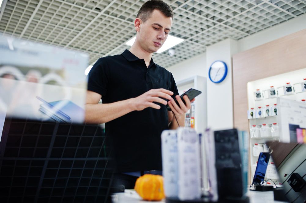 seller-man-mobile-phone-professional-consultant-in-tech-store-or-shop