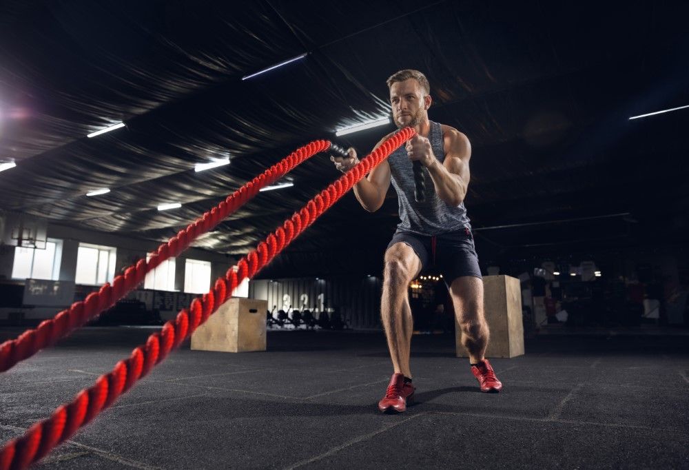 Young healthy male athlete doing exercises in the gym