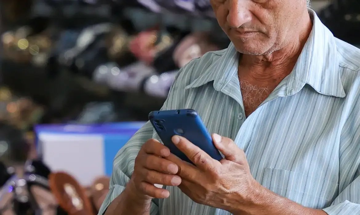 Pessoa segurando um telefone celular.