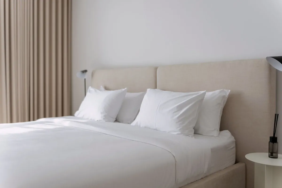Quarto mobiliado com cama de casal e decoração em tons neutros