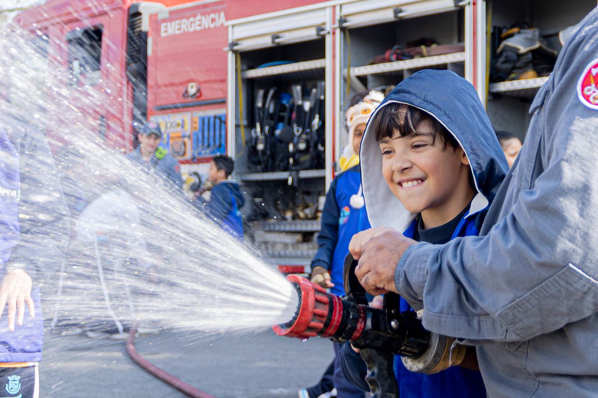 Bombeiros apresentam equipamentos de combate a incêndio para alunos durante ação educativa contra queimadas em escola de Itapevi