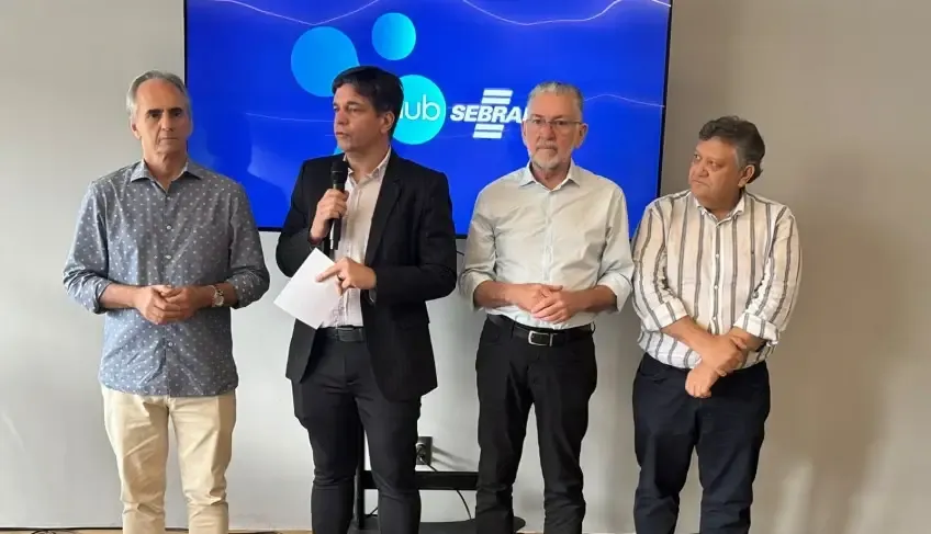 Rodrigo Soares, presidente do Sebrae Nacional, fala ao microfone ao lado de outros três dirigentes durante evento em João Pessoa, com telão exibindo o logotipo do Sebrae ao fundo